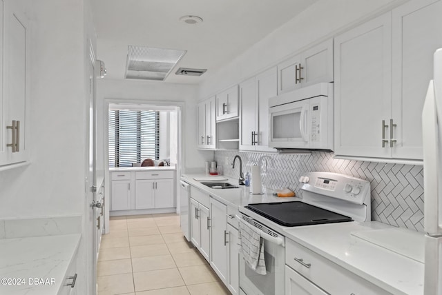 kitchen featuring sink, light tile patterned floors, backsplash, white cabinetry, and white appliances