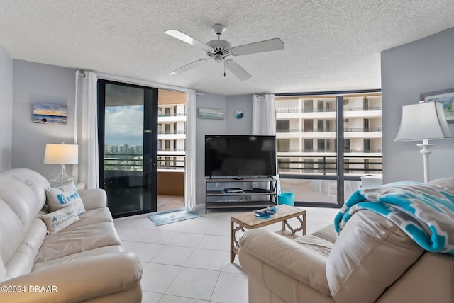 tiled living room with a textured ceiling, expansive windows, and ceiling fan