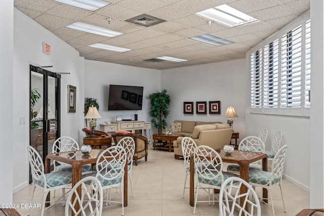 dining area featuring a drop ceiling and light tile patterned floors