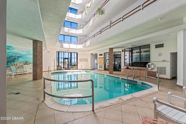 view of swimming pool featuring a hot tub and a skylight