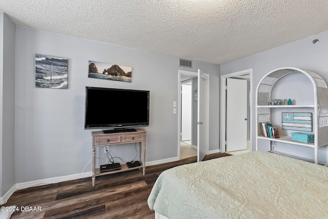 bedroom featuring dark wood-type flooring and a textured ceiling