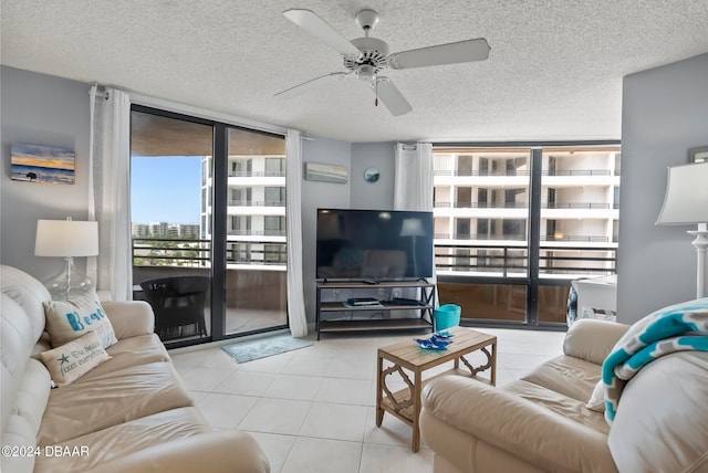 tiled living room featuring ceiling fan, a textured ceiling, and floor to ceiling windows