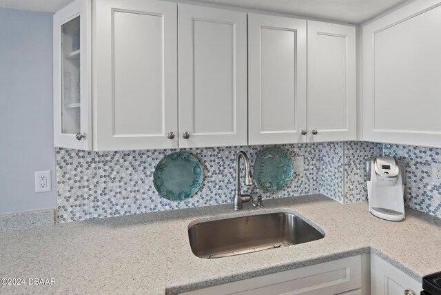 kitchen featuring white cabinetry, sink, and decorative backsplash