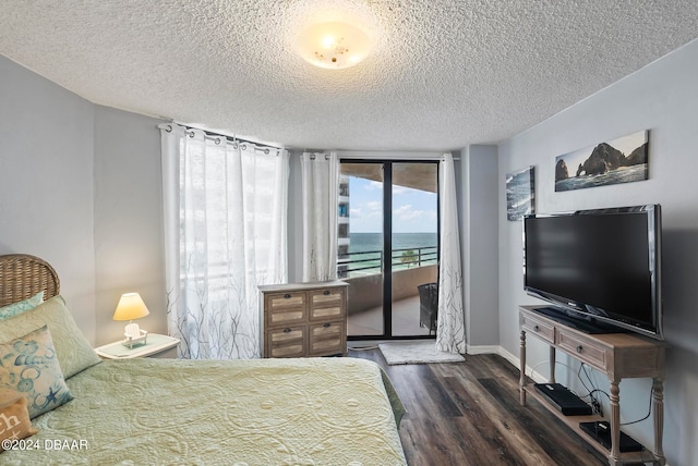 bedroom with a textured ceiling, dark hardwood / wood-style floors, and access to exterior