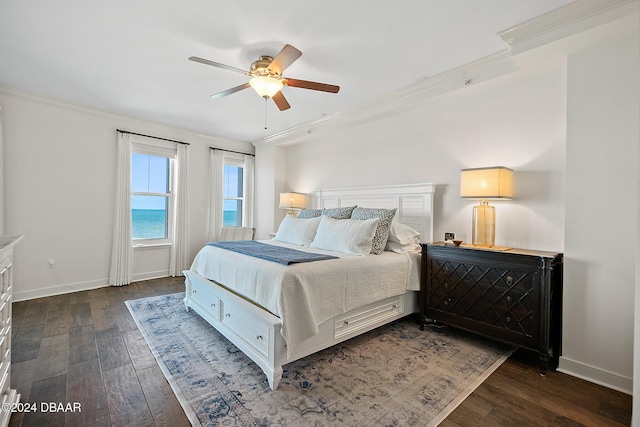 bedroom featuring dark hardwood / wood-style flooring, ceiling fan, and ornamental molding