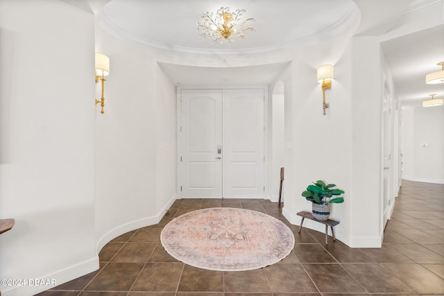 entryway with dark tile patterned flooring and an inviting chandelier