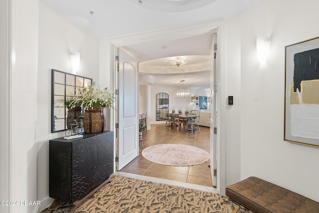 corridor featuring tile patterned floors and a notable chandelier