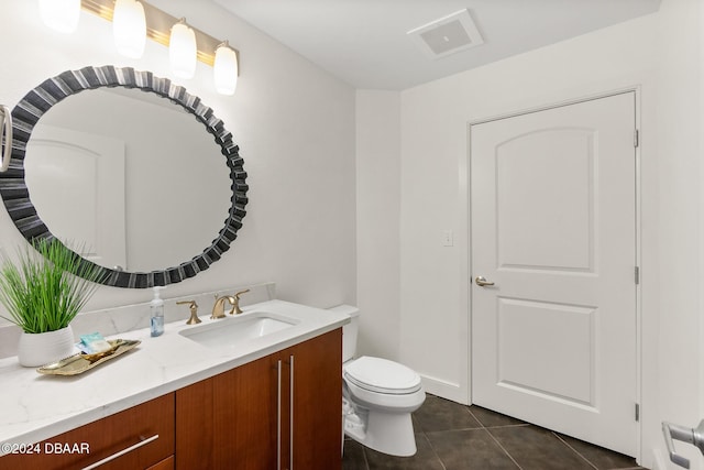 bathroom with tile patterned flooring, vanity, and toilet