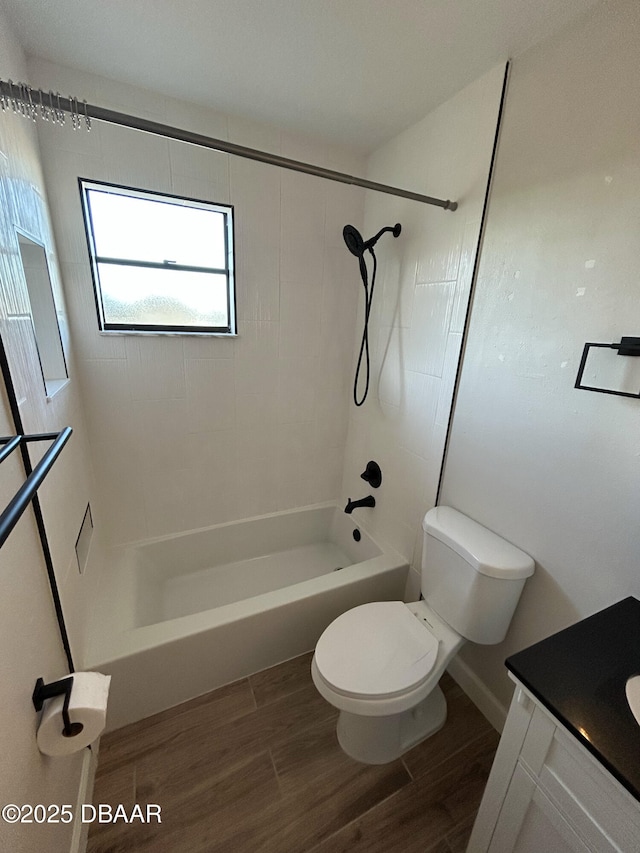 full bath with toilet, washtub / shower combination, wood finished floors, and vanity