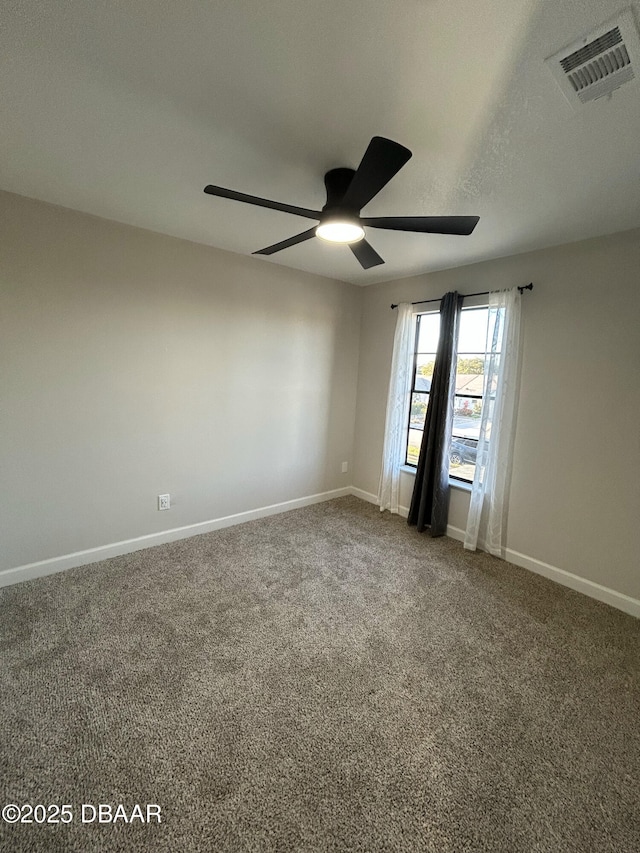 carpeted spare room featuring baseboards, visible vents, ceiling fan, and a textured ceiling