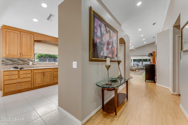 916 Ashmeade Ct, Port Orange, FL 32127 - hallway featuring lofted ceiling, recessed lighting, arched walkways, and light wood finished floors