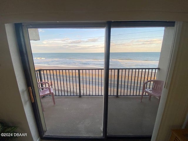 balcony featuring a water view and a beach view