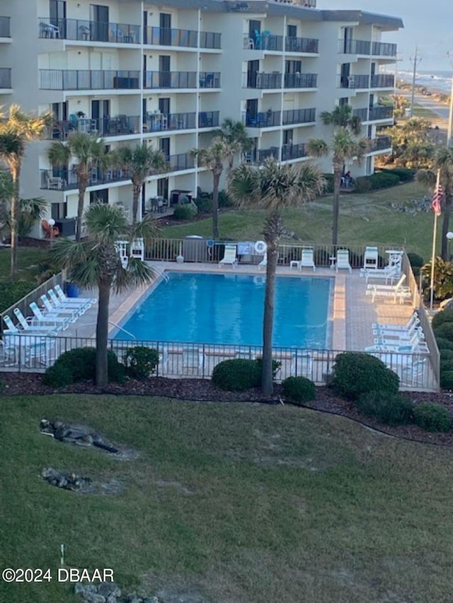 view of swimming pool featuring a lawn