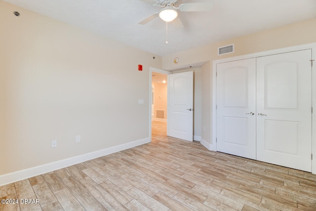 unfurnished bedroom featuring light wood-type flooring, ceiling fan, and a closet