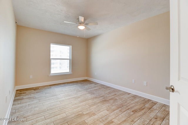 empty room with light hardwood / wood-style floors, ceiling fan, and a textured ceiling