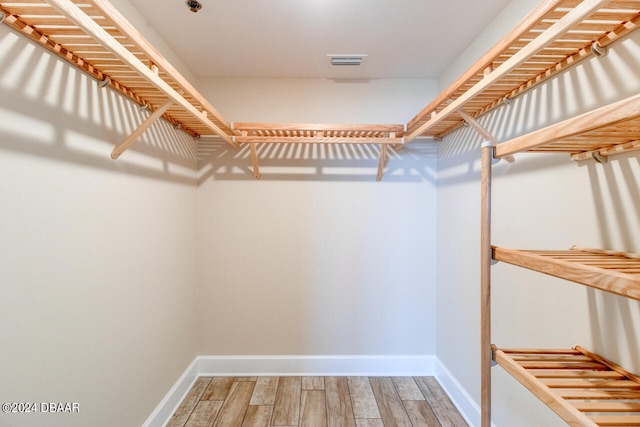 spacious closet with hardwood / wood-style flooring