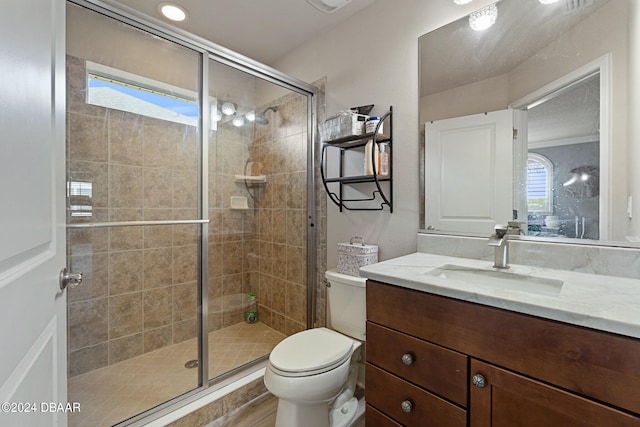 bathroom with vanity, toilet, and a shower with door