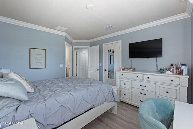 bedroom with ornamental molding and light hardwood / wood-style flooring