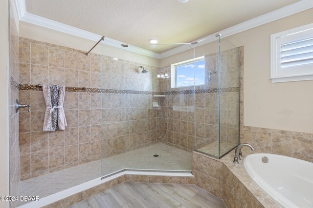 bathroom featuring ornamental molding, hardwood / wood-style flooring, and plus walk in shower