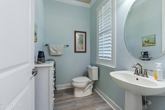 bathroom featuring ornamental molding, hardwood / wood-style floors, sink, and toilet