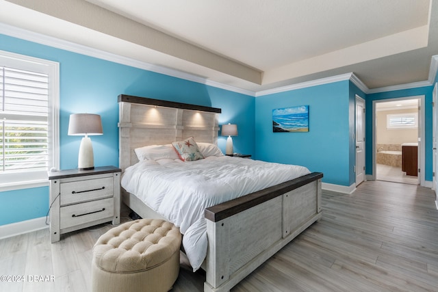 bedroom with crown molding, light hardwood / wood-style floors, and ensuite bathroom