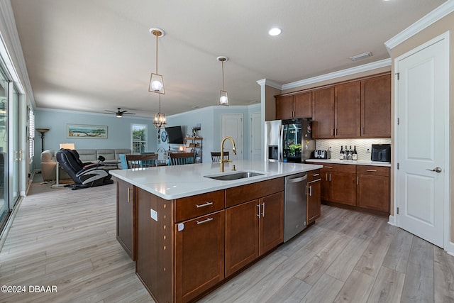 kitchen with a kitchen island with sink, stainless steel appliances, sink, ceiling fan, and light hardwood / wood-style flooring