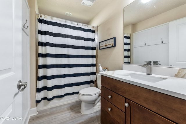 full bathroom with hardwood / wood-style floors, vanity, toilet, and shower / tub combo