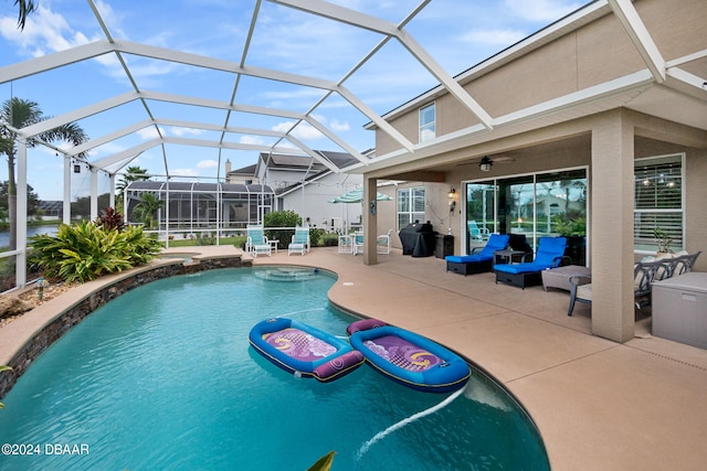 view of swimming pool with outdoor lounge area, a patio, glass enclosure, and ceiling fan