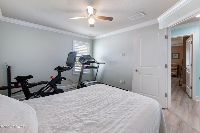 bedroom with a textured ceiling, light wood-type flooring, ceiling fan, and crown molding