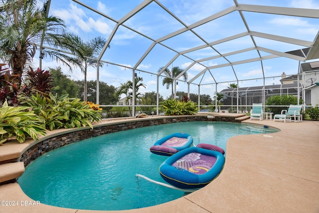 view of swimming pool featuring glass enclosure and a patio area