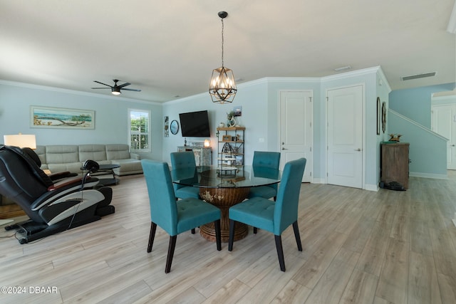 dining space featuring light wood-type flooring, crown molding, and ceiling fan with notable chandelier