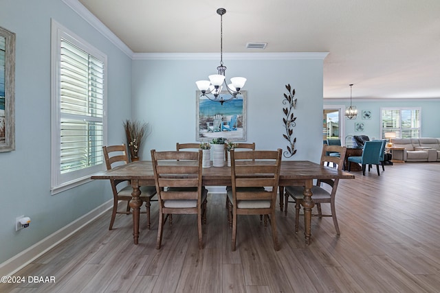 dining room with wood-type flooring, a chandelier, and crown molding