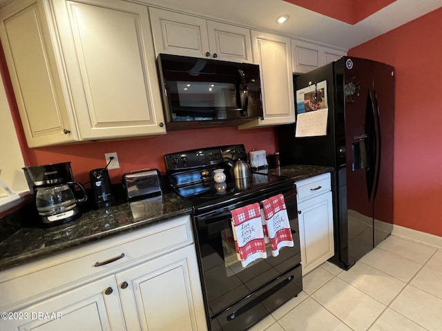 kitchen featuring white cabinetry, black appliances, light tile patterned floors, and dark stone countertops