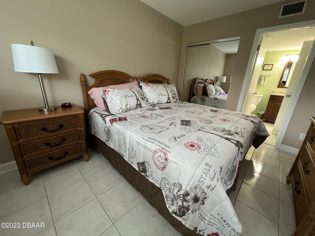 tiled bedroom featuring connected bathroom and a closet