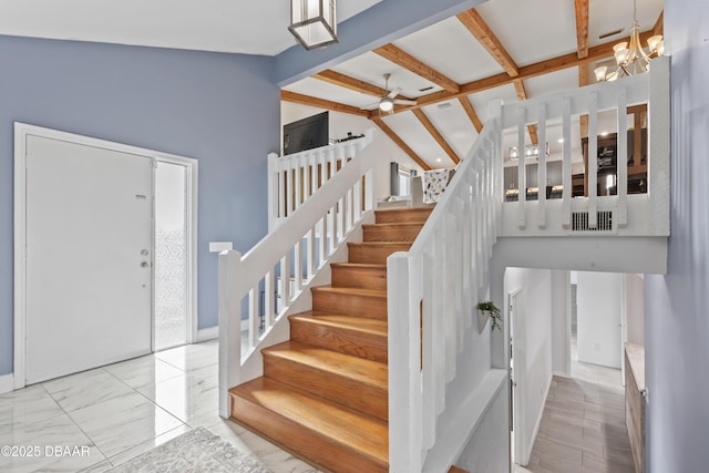 entrance foyer featuring vaulted ceiling with beams and ceiling fan with notable chandelier