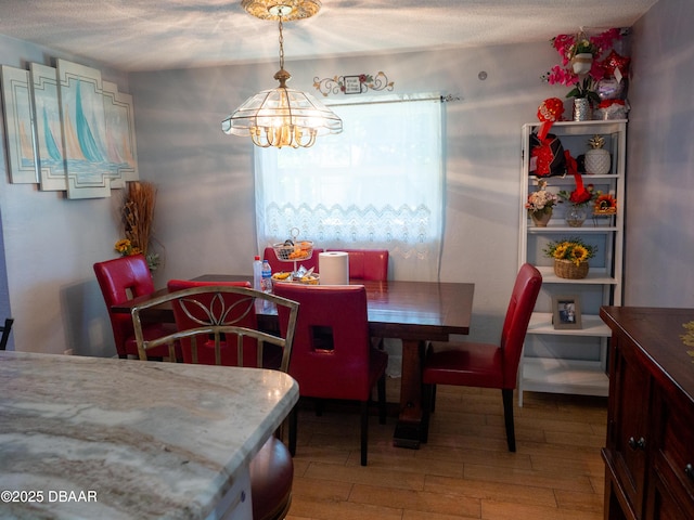 1325 Laurel Dr, Daytona Beach, FL 32117 - dining area featuring a chandelier, wood finished floors, and a textured ceiling