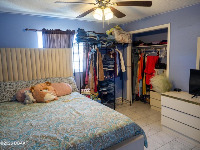 1325 Laurel Dr, Daytona Beach, FL 32117 - bedroom with a closet, a ceiling fan, a textured ceiling, and marble look tiles