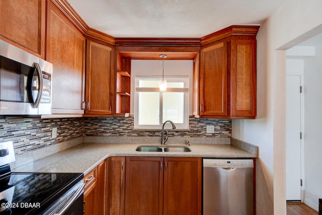 kitchen with sink, appliances with stainless steel finishes, wood-type flooring, pendant lighting, and decorative backsplash