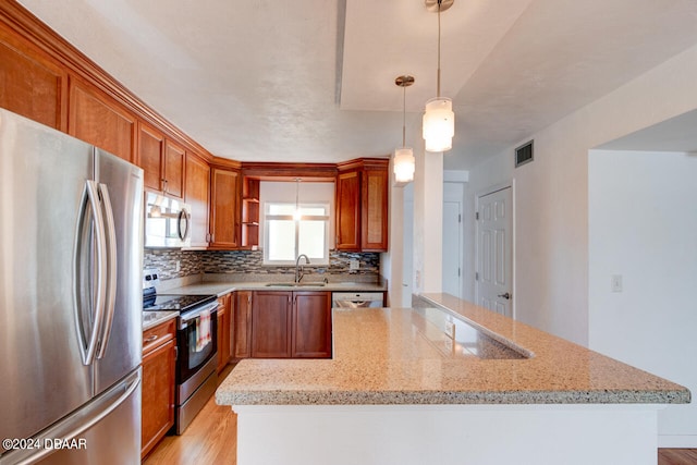 kitchen with light hardwood / wood-style flooring, decorative light fixtures, light stone counters, and stainless steel appliances