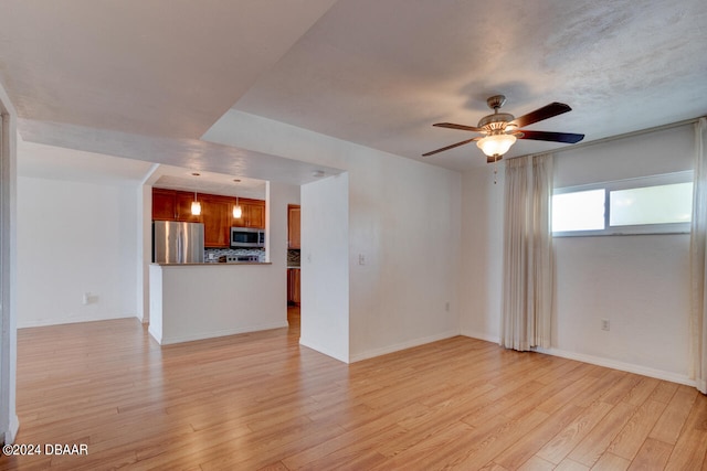 unfurnished living room with ceiling fan and light hardwood / wood-style floors