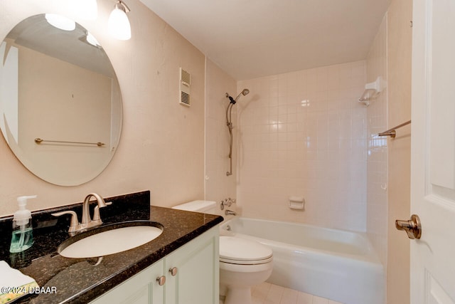 full bathroom featuring tile patterned floors, vanity, tiled shower / bath combo, and toilet