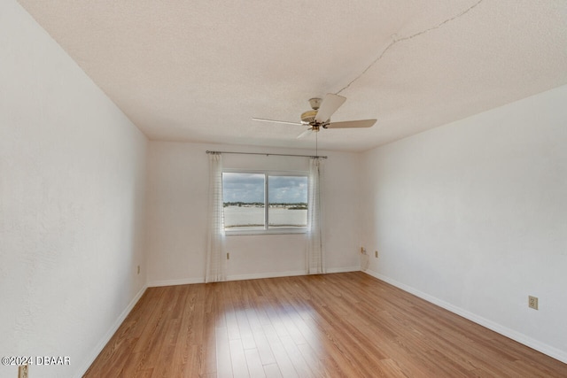 empty room with a textured ceiling, hardwood / wood-style flooring, and ceiling fan