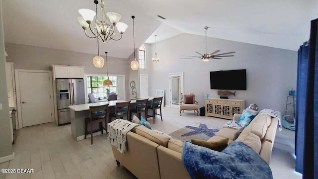 living area featuring light wood-style floors, visible vents, high vaulted ceiling, and ceiling fan with notable chandelier