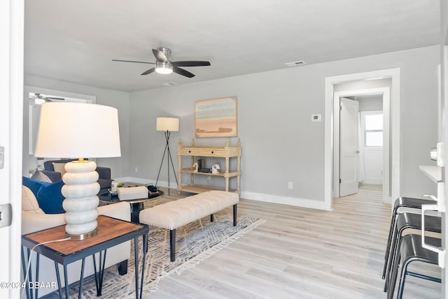 living room featuring light wood-type flooring and ceiling fan