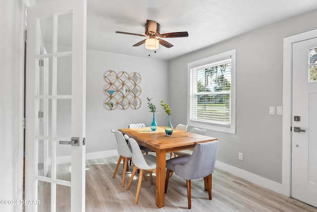 dining space with french doors, light wood-type flooring, and ceiling fan