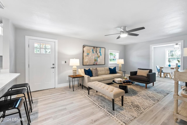 living room with a wealth of natural light, ceiling fan, and light hardwood / wood-style flooring