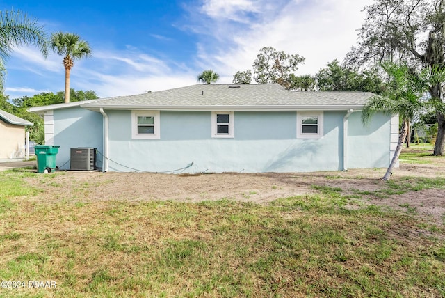 back of house with a lawn and central AC unit