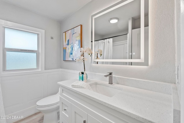 bathroom with toilet, vanity, and hardwood / wood-style flooring