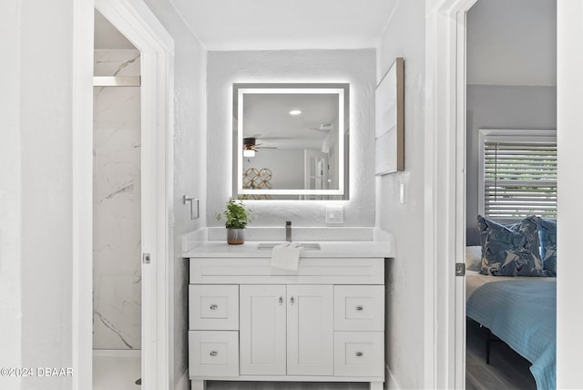 bathroom featuring ceiling fan, vanity, and tiled shower