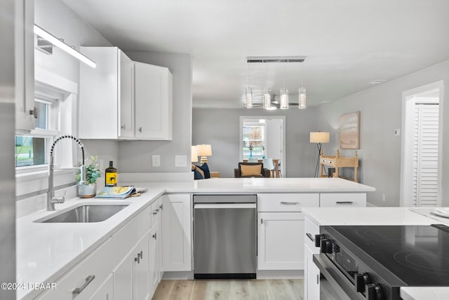 kitchen featuring pendant lighting, sink, stainless steel dishwasher, white cabinetry, and light wood-type flooring